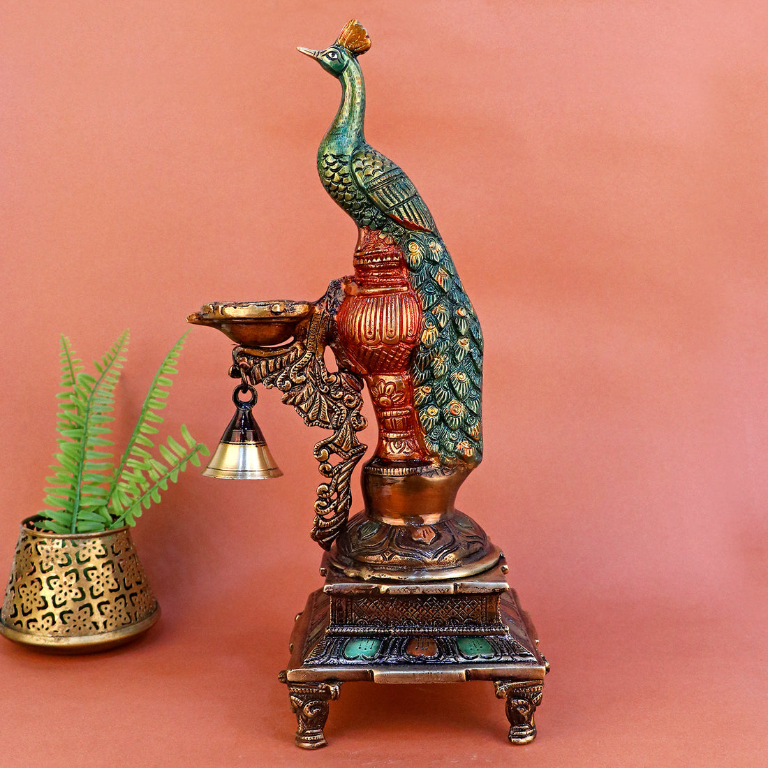 Satvik Stores Presents Brass Peacock Diya Stand. Any festive occasion will be made wonderfully auspicious by the grace and beauty of the Peacock Brass Handcrafted Hanging Diya. Given that it was made by hand, the piece's abnormalities and flaws only serve to enhance Diya's allure and charisma.