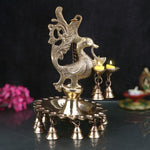 A stunning Brass Peacock Diya Hanging with Bells, featuring a graceful peacock design with a shiny brass finish.  India’s Largest Pooja Accessories Brand – www.satvikstore.in